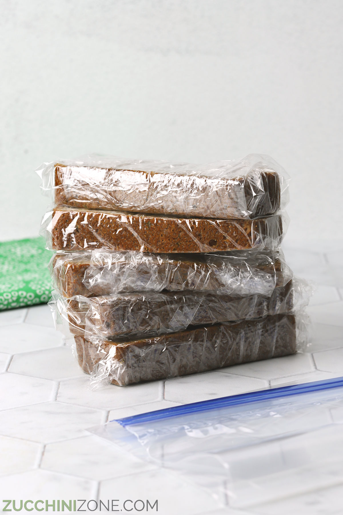 Zucchini bread slices wrapped in plastic wrap.