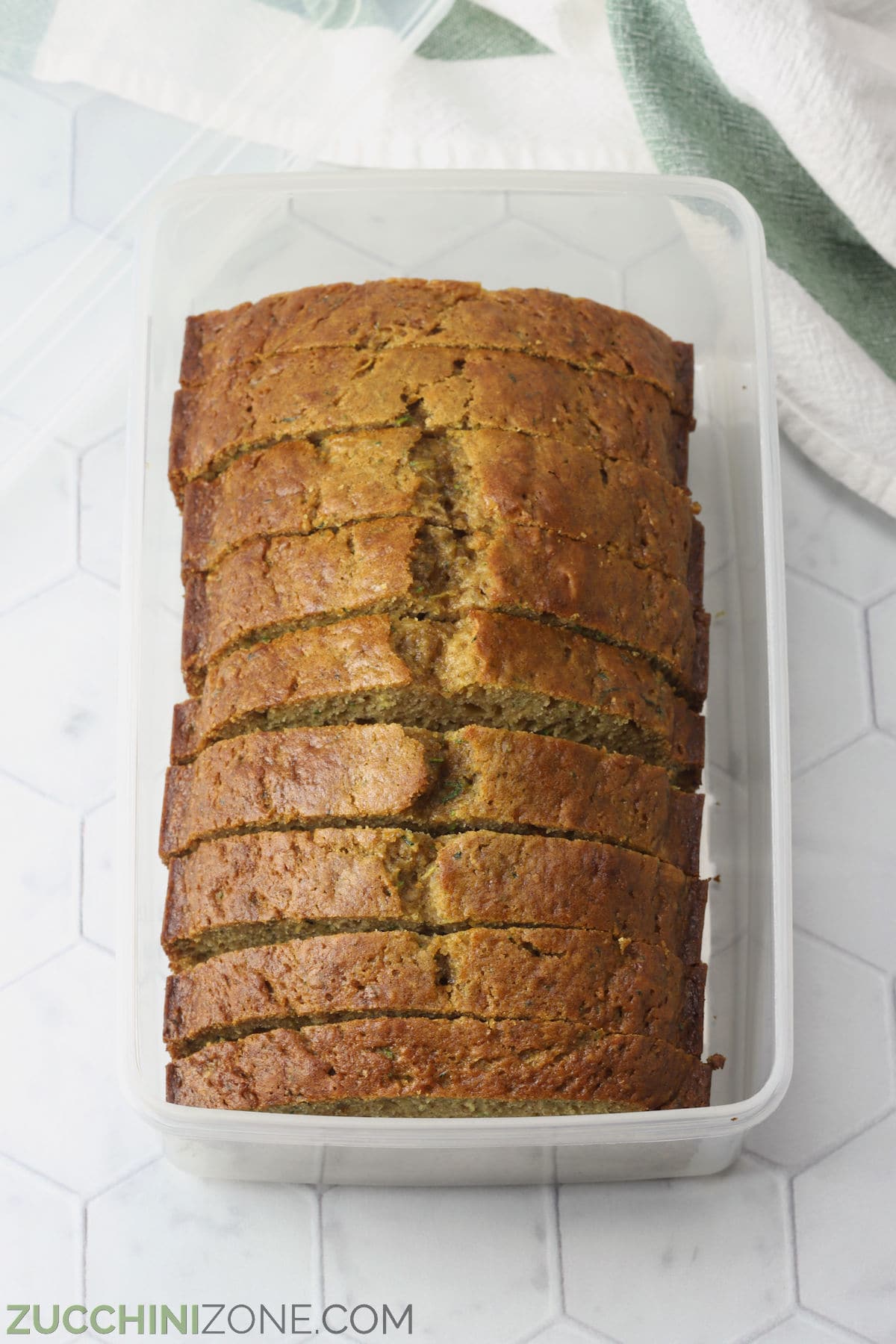 Sliced zucchini bread in a plastic storage container.