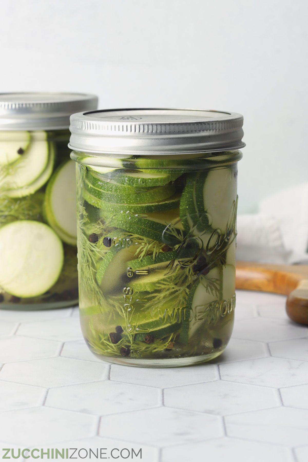 A jar of dill zucchini pickles on the counter top.