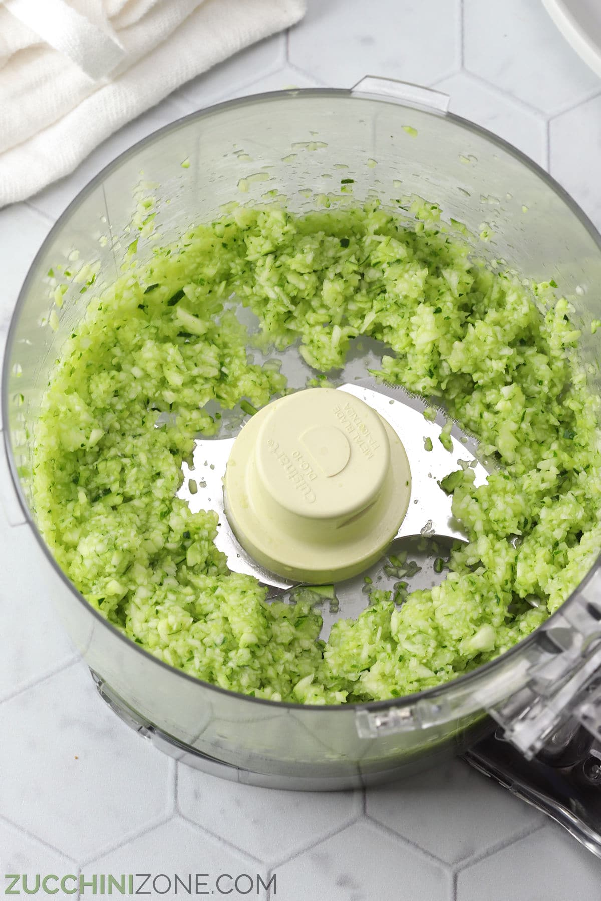 Chopped zucchini in a food processor.