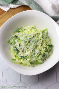 A white bowl filled with zucchini noodle alfredo.