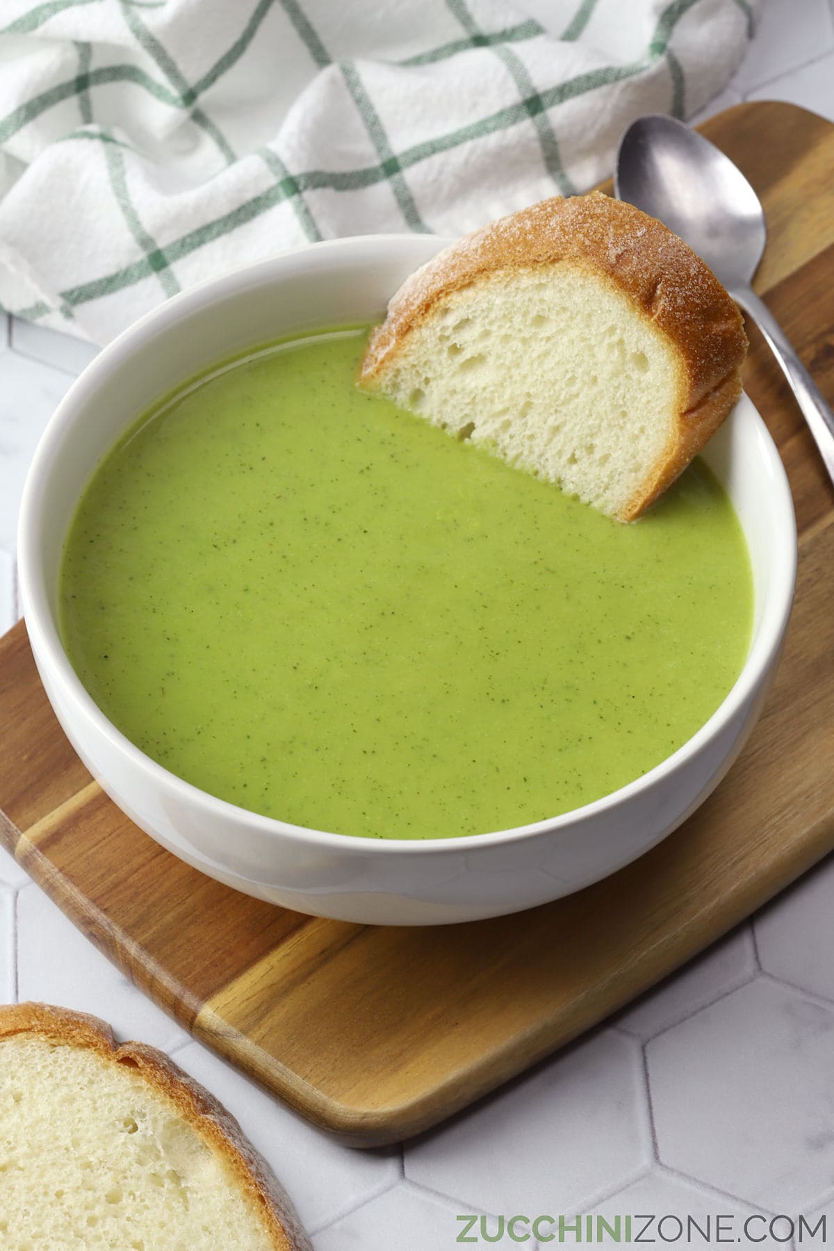White bowl filled with creamy zucchini leek soup.