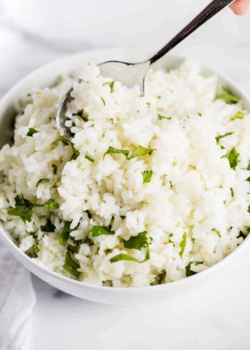 Cilantro lime rice in a bowl with a metal spoon.