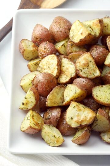 Roasted potatoes on a white plate.
