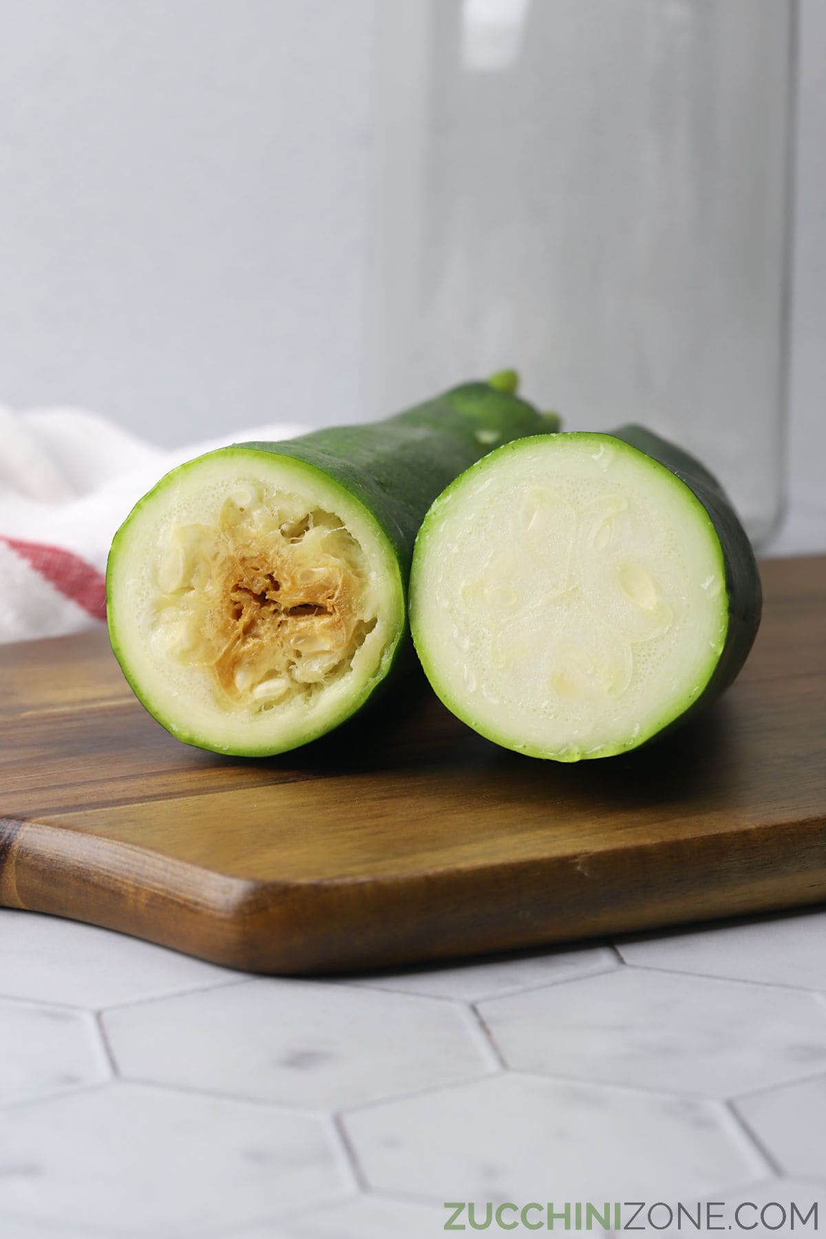 Rotten zucchini next to a fresh zucchini, to show the difference between the two.