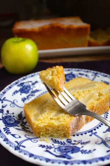 Slice of cornbread apple loaf on a blue and white decorative plate.