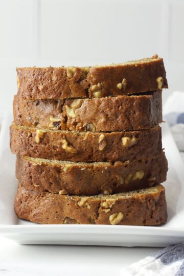 A stack of sliced banana nut bread on a white plate.