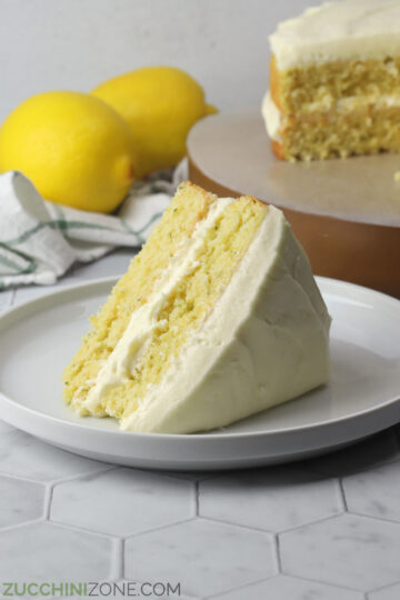 A slice of lemon zucchini cake on a white plate.