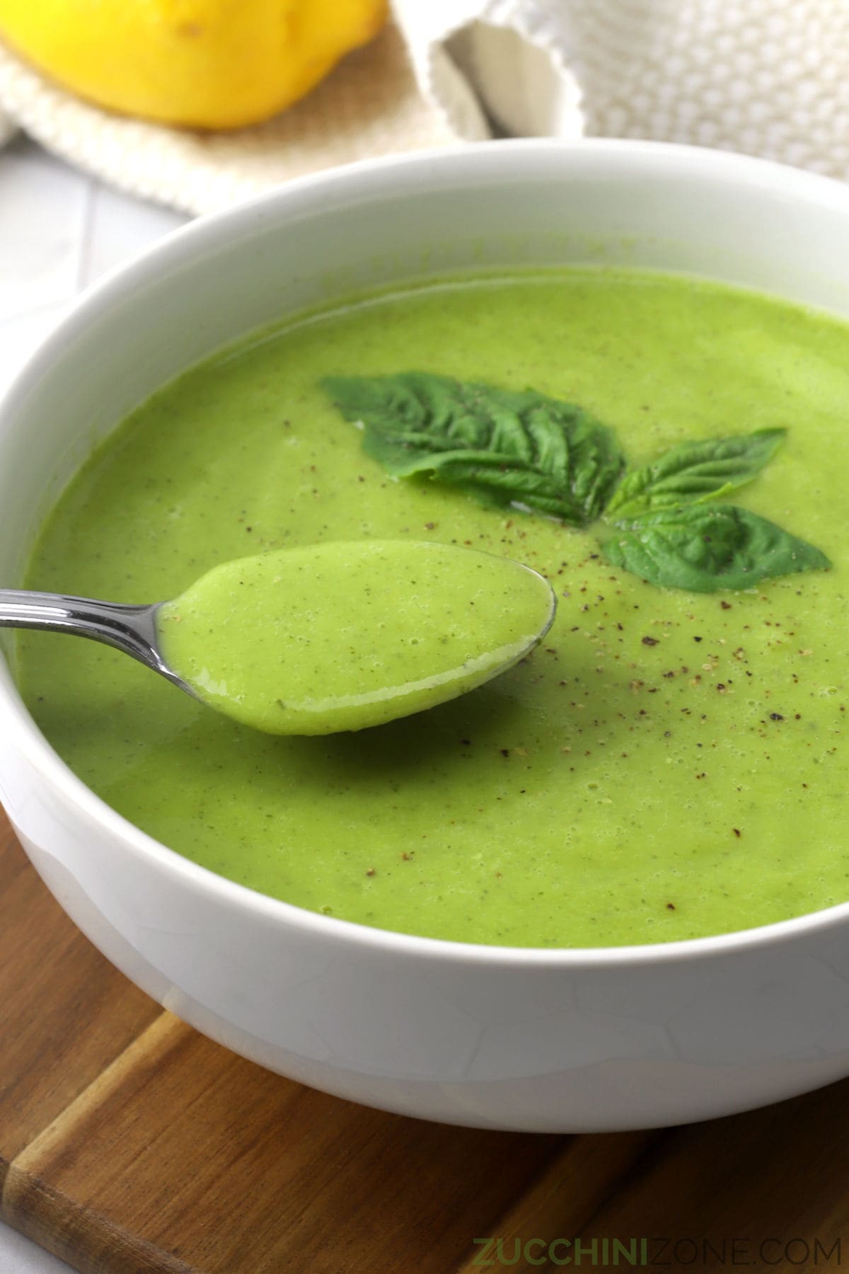 Close up of zucchini basil soup with a spoon.