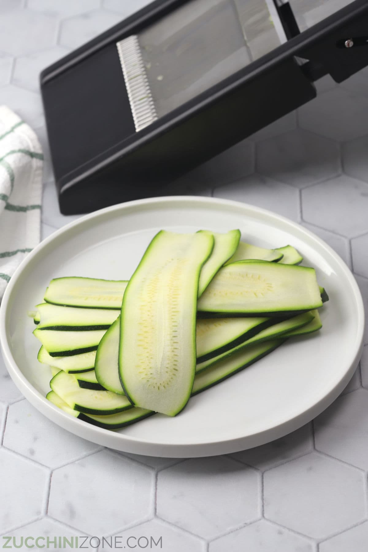 https://zucchinizone.com/wp-content/uploads/2023/06/zucchini-sliced-on-mandoline.jpg