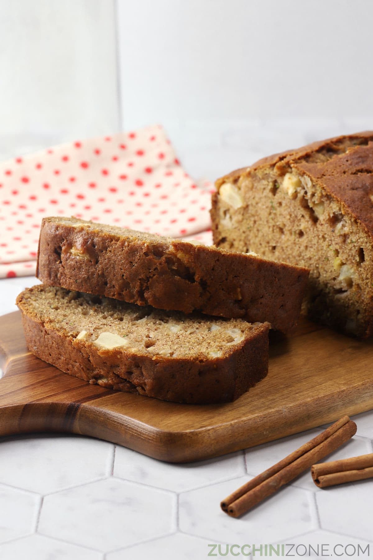 Slices of apple zucchini bread on a wooden serving board.