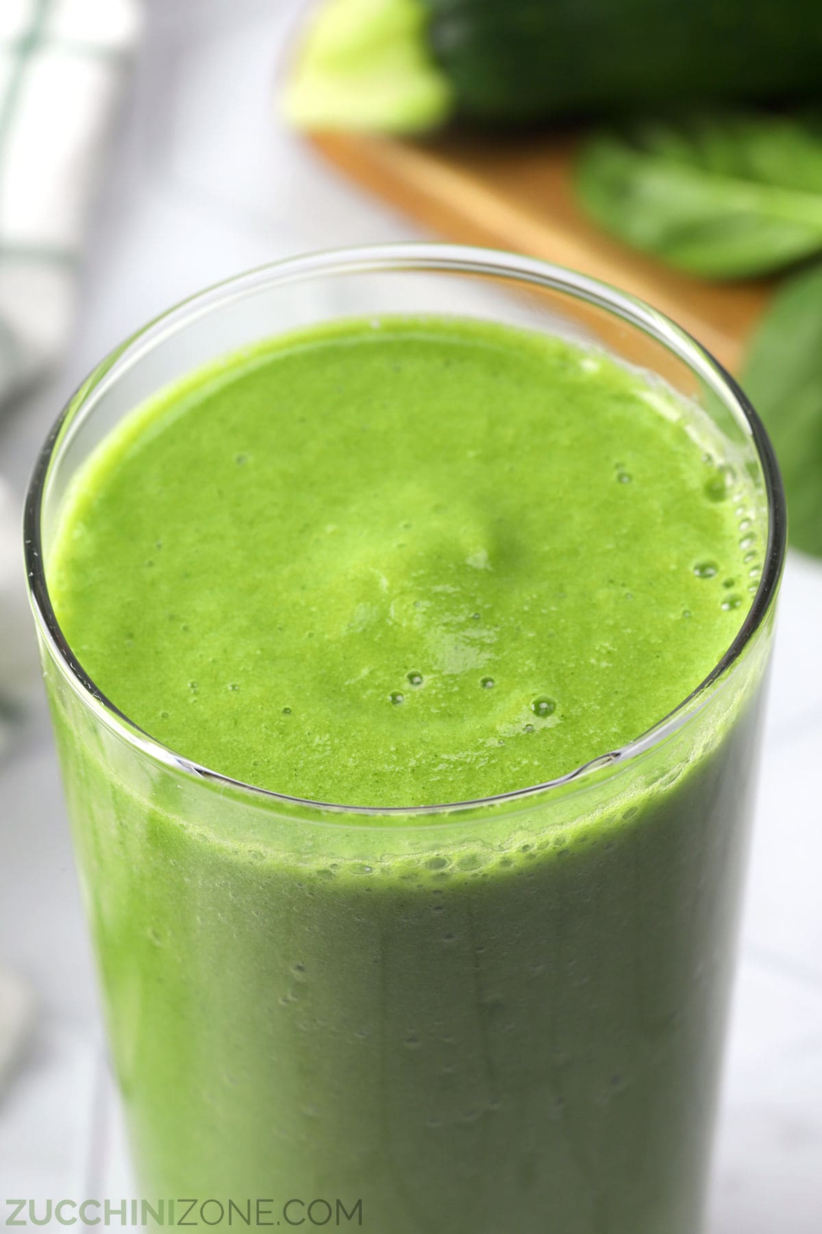 Close up of a green apple smoothie in a tall glass.