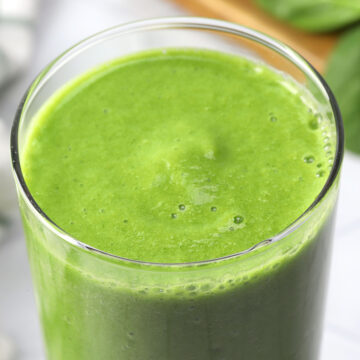 Close up of a green apple smoothie in a tall glass.