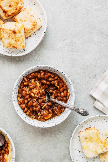 A white bowl of molasses baked beans.