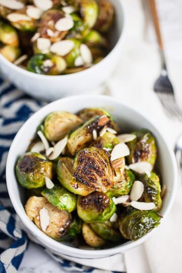 Two white bowls of Brussels sprouts.