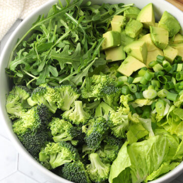 A large bowl filled with green vegetables to make an all green salad.