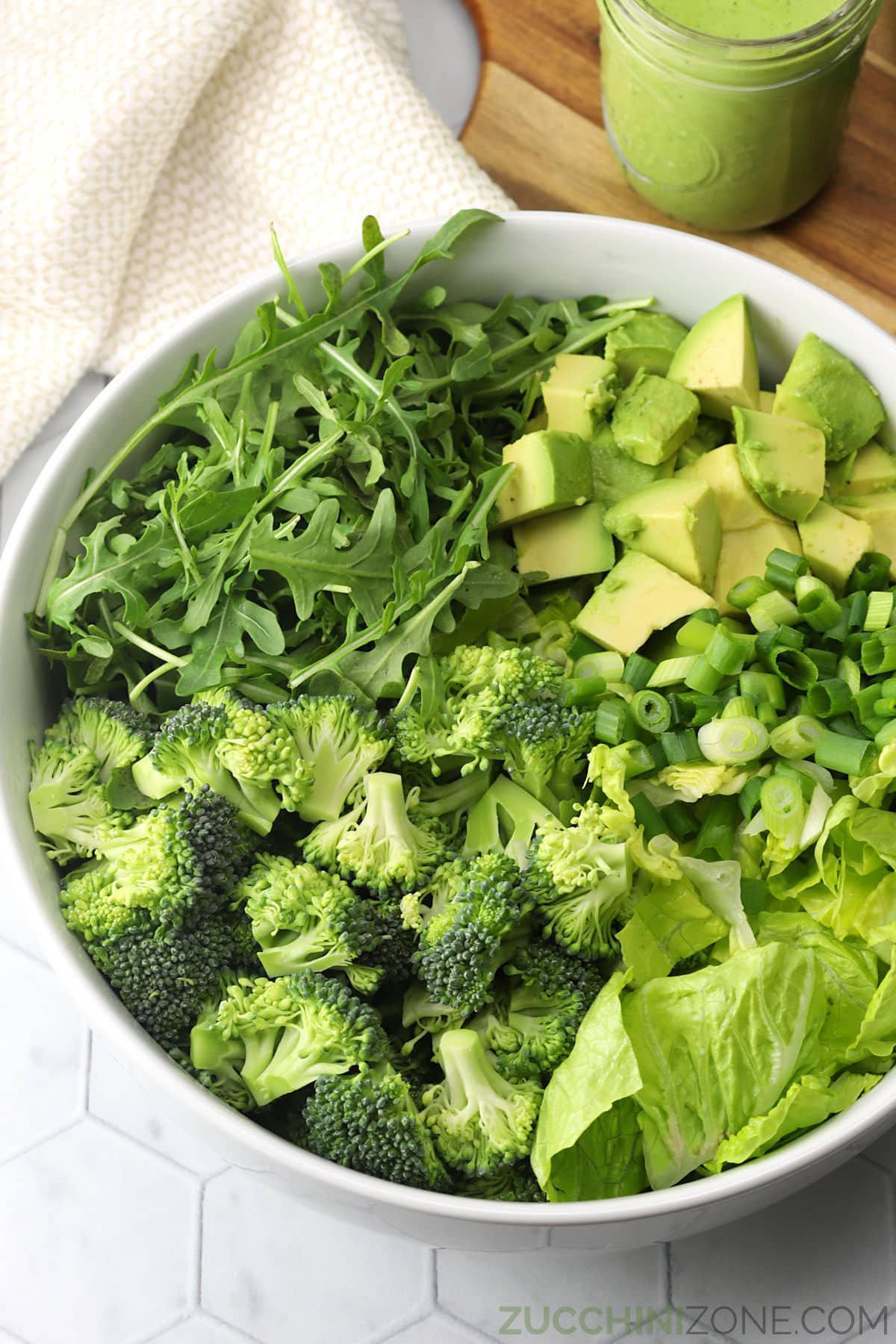 A large bowl filled with green vegetables to make an all green salad.