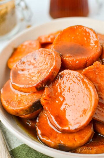 A white dish of glazed sweet potatoes.