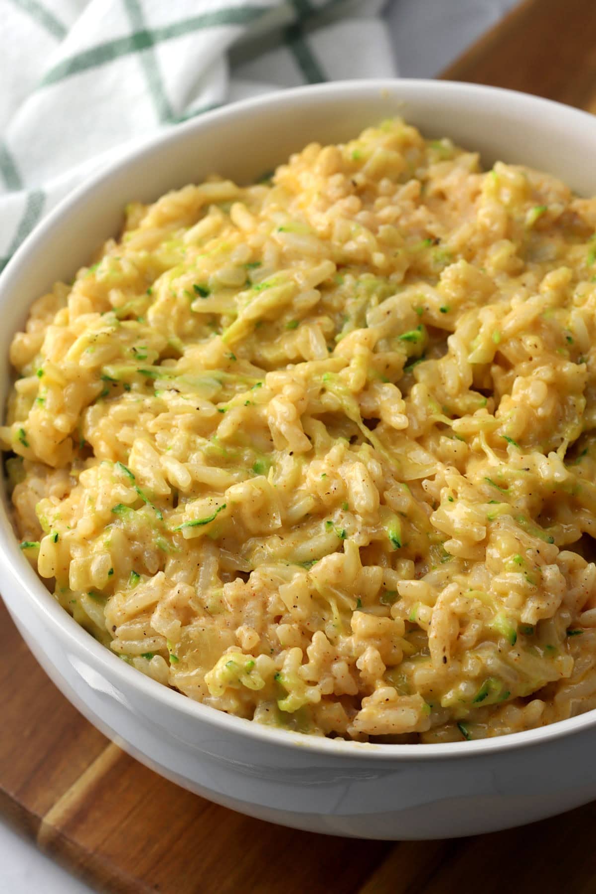 A bowl of cheesy rice with grated zucchini.
