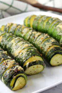 Partially sliced zucchini with cheese in the cracks.