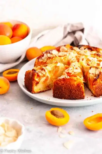 Wedges of apricot almond cake on a plate.
