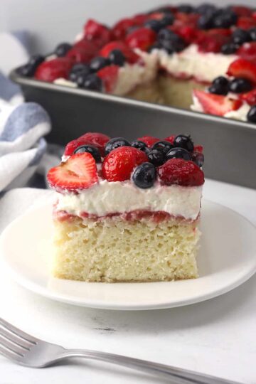 A slice of sheet cake topped with frosting and fruit.