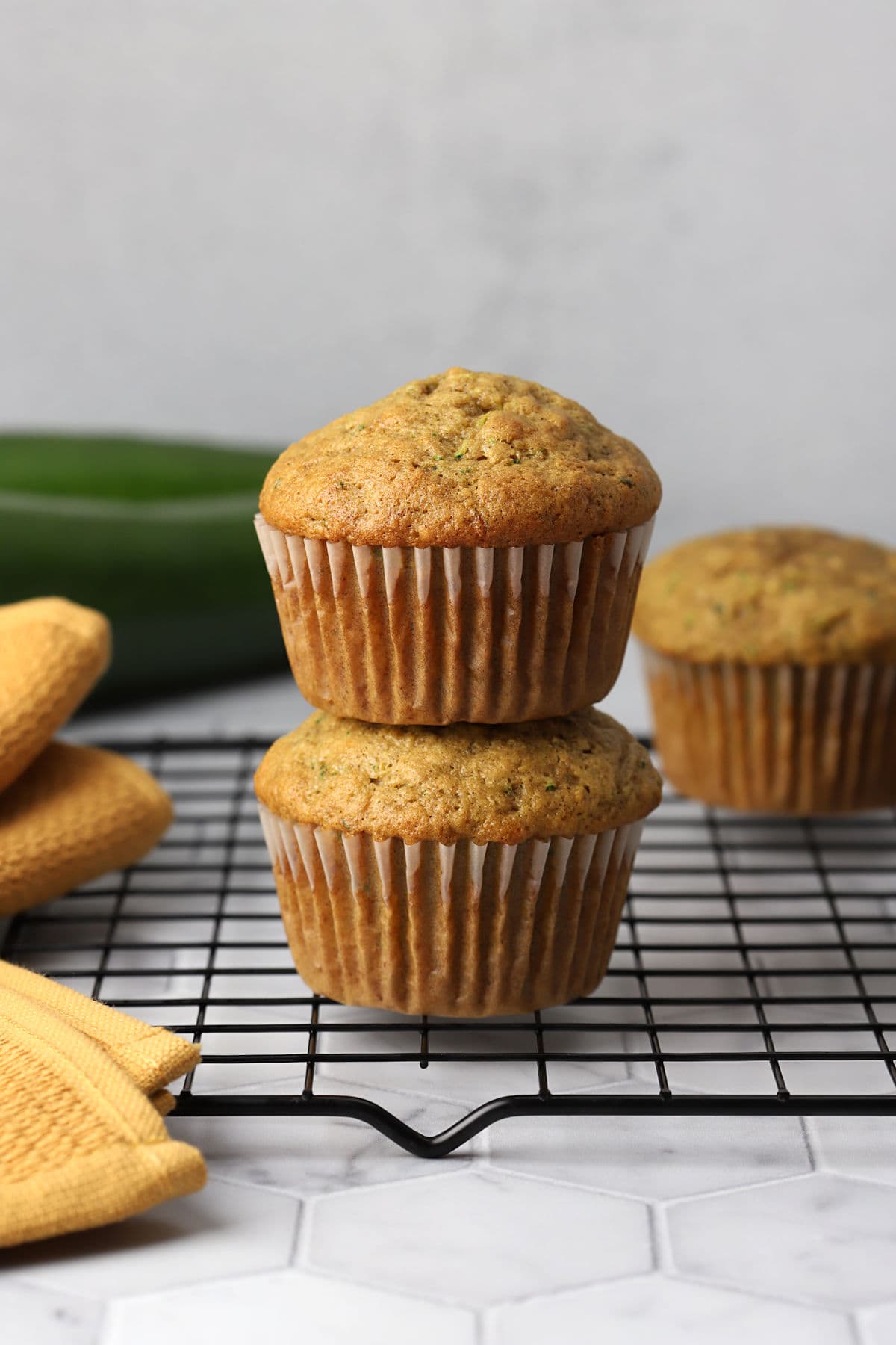 A stack of zucchini muffins on a cooling rack.